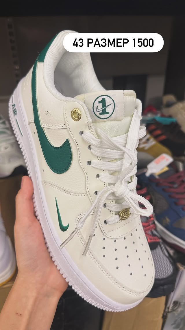 Nike Air Force 1 белого цвета с зелеными элементами.
